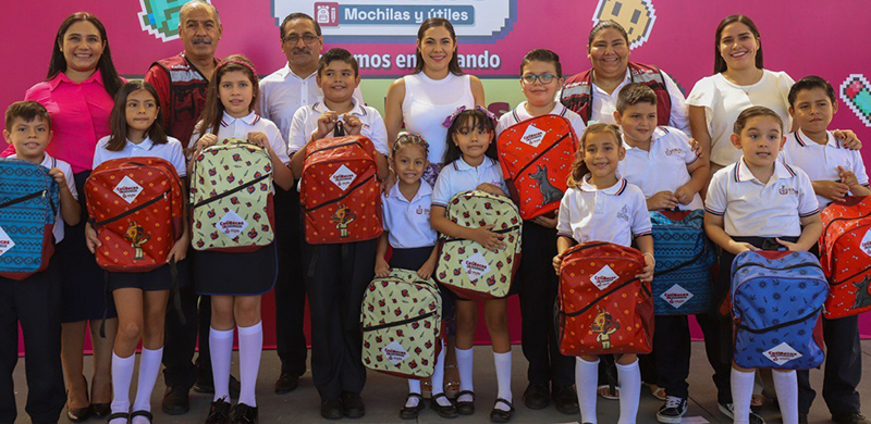 Niños de 7 a 8 años, estudiantes de primaria con mochilas y uniformes  escolares, un niño regala flores a una niña