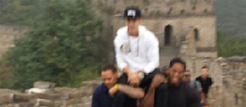 Justin Bieber siendo cargado por sus guardaespaldas en la Gran Muralla. Foto de YouTube